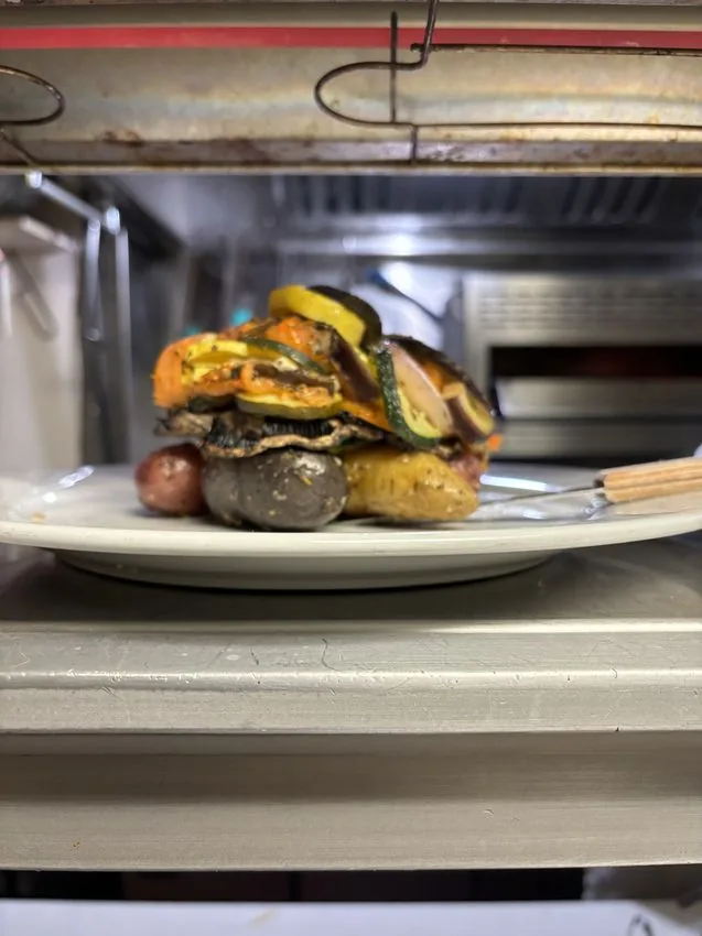 Stacked roasted vegetables on the pass